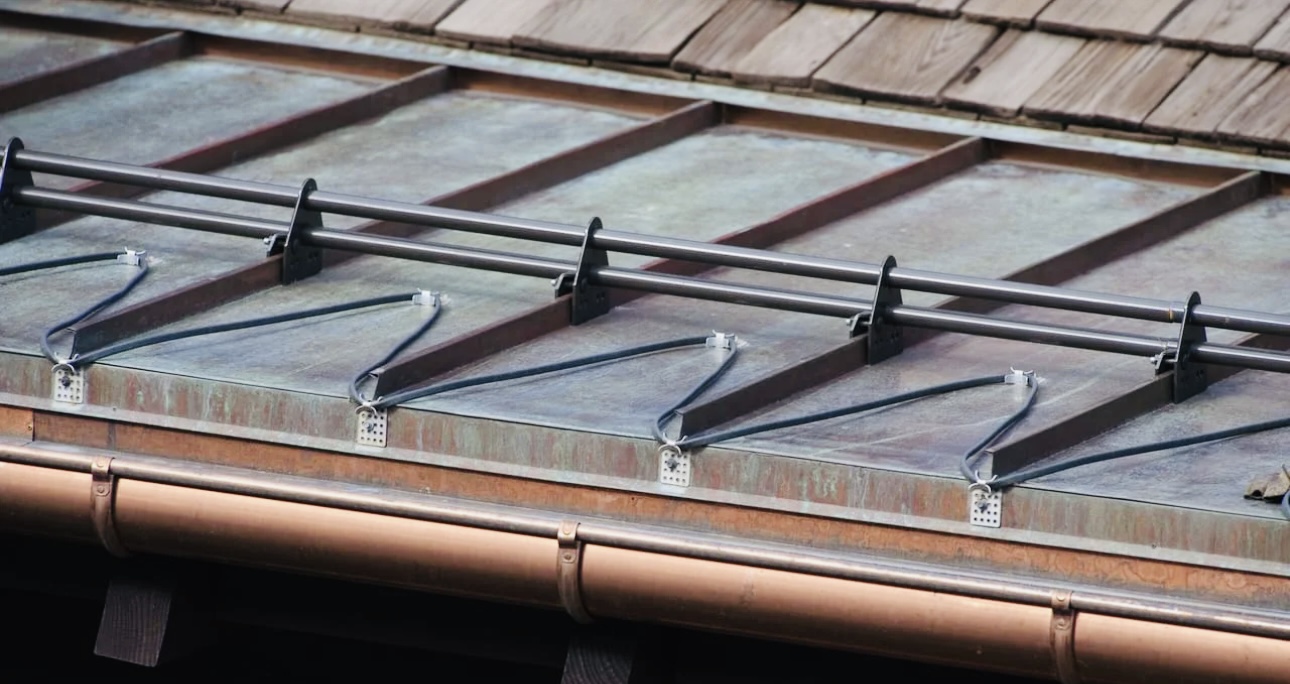 Snow guards mounted on a metal roof to prevent accumulated snow from sliding off abruptly.